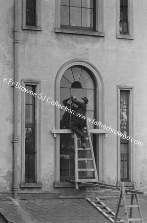 MAN FITTING LEADE GLASS AT RERE OF 35 LEESON STREET